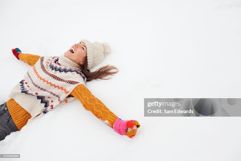 Enthusiastic woman making snow angel