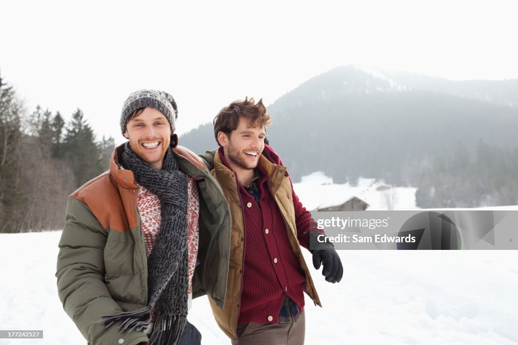 Portrait of happy men walking in snowy field