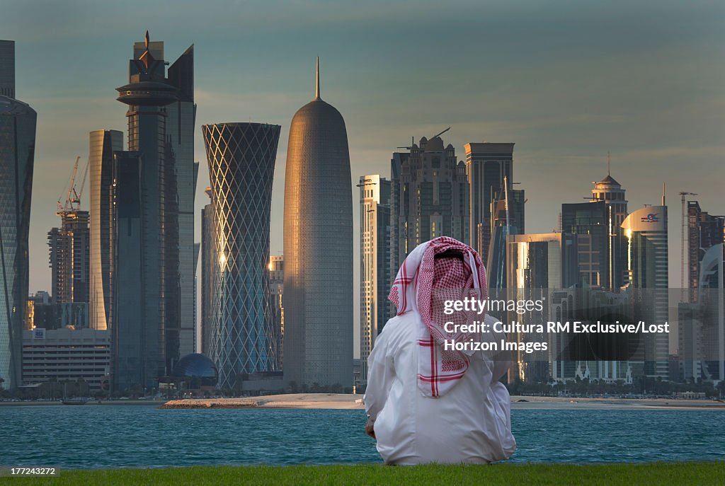 Man looking at futuristic skyscrapers of downtown Doha, Qatar