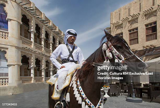 mounted policeman on an arabian horses in old doha, qatar - bereden politie stockfoto's en -beelden