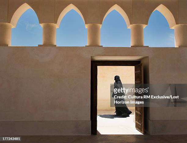 arab woman exiting a mosque, doha, qatar - doha people stock pictures, royalty-free photos & images