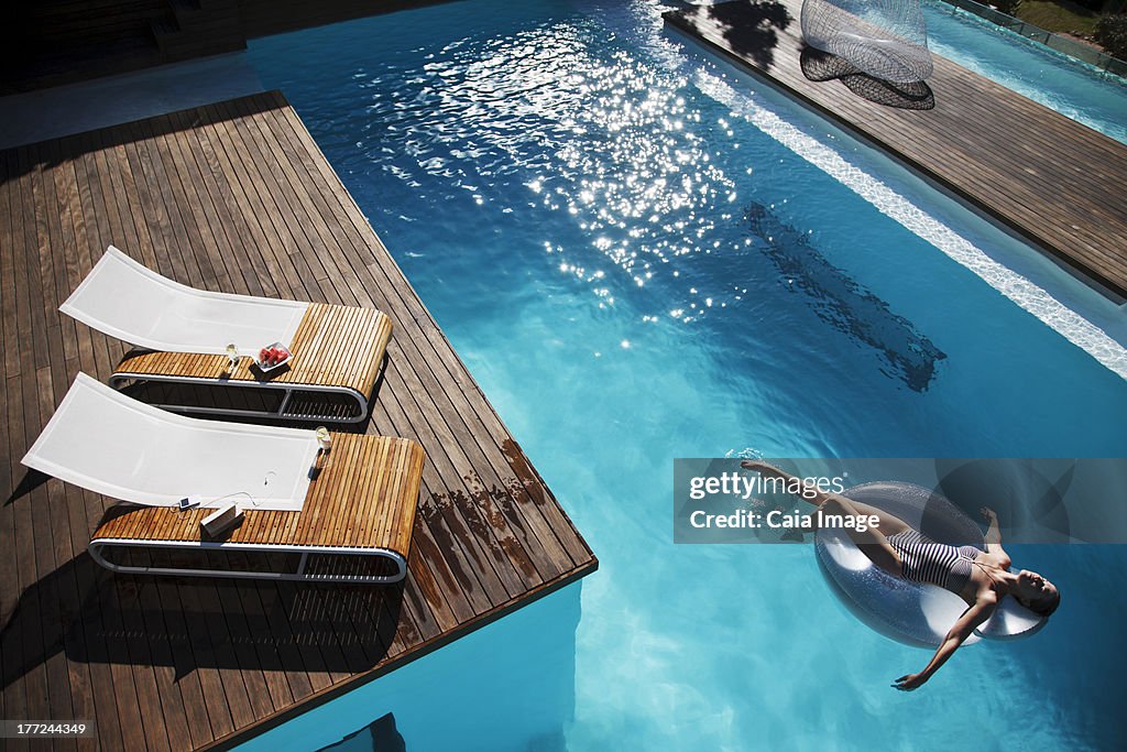 Mulher Flutuar na Boia na piscina de luxo