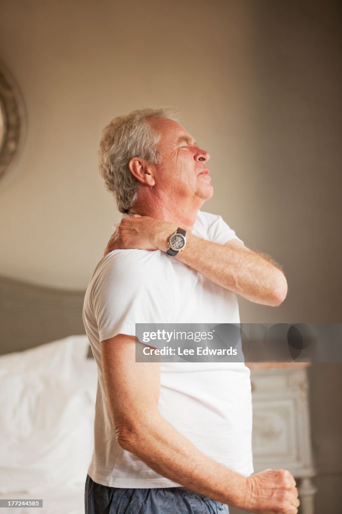 Senior man holding shoulder in pain