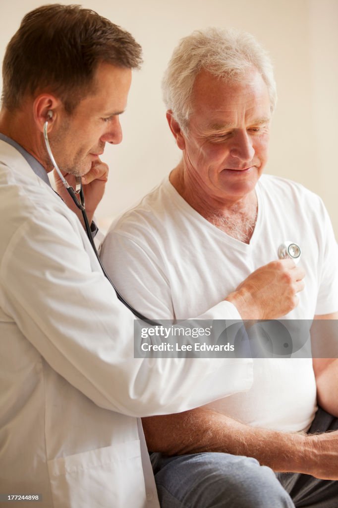 Arzt überprüfen senior Mann's Herz mit Stethoskop