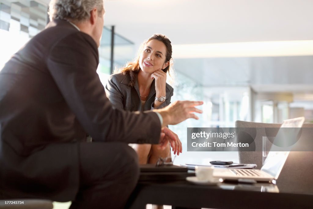 Businessman and businesswoman talking in lobby