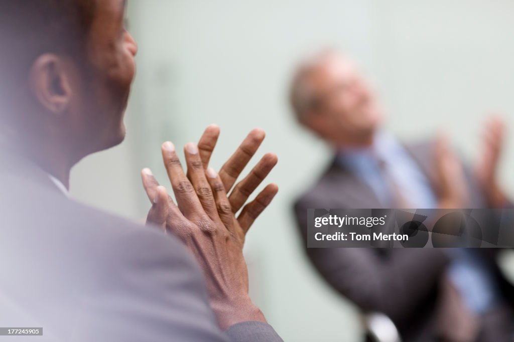 Businessmen clapping in meeting