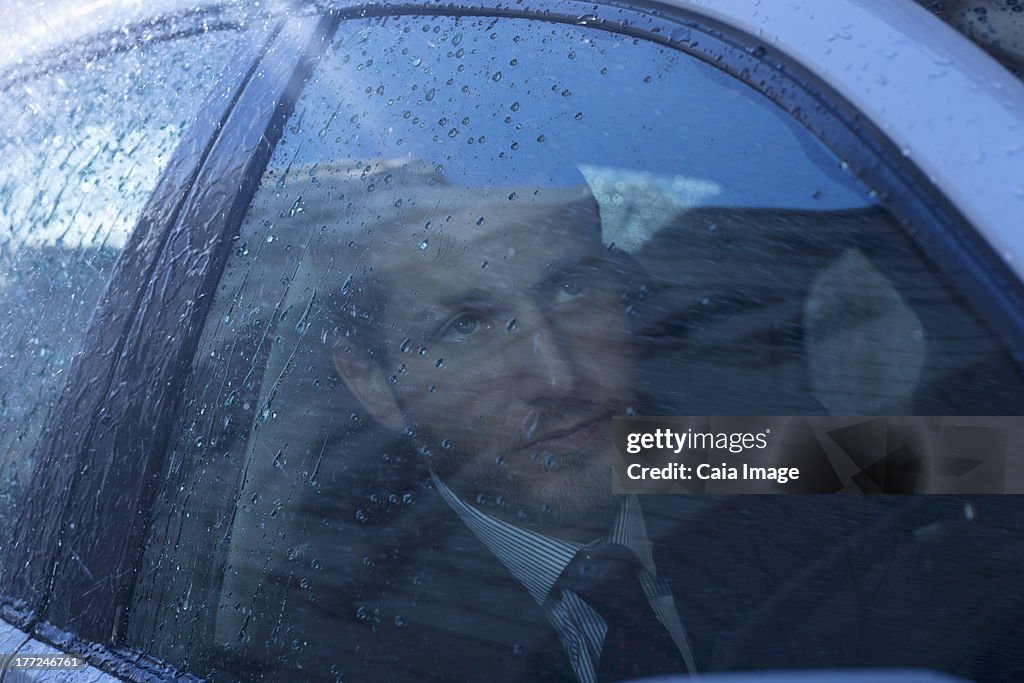 Nahaufnahme der Geschäftsmann im Auto nachschlagen bei Regen