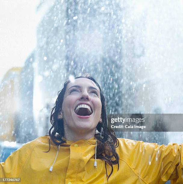 begeisterte frau stand im regen - caiaimage stock-fotos und bilder