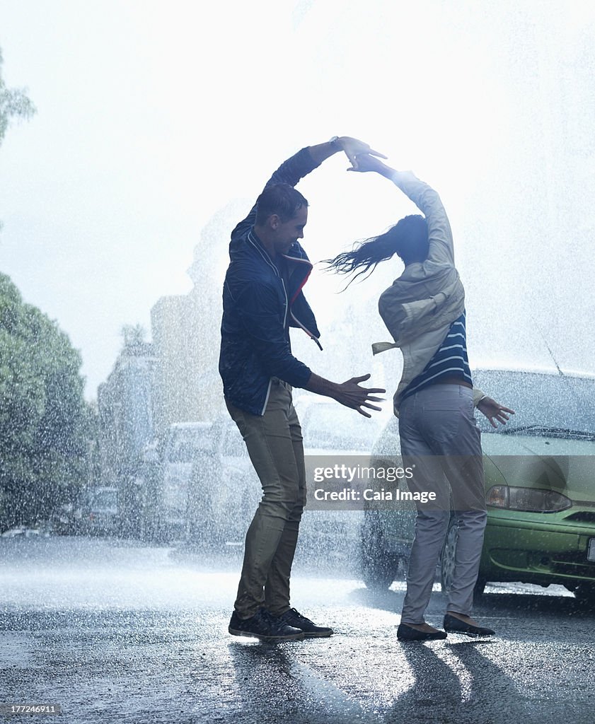 Happy couple dancing in rain