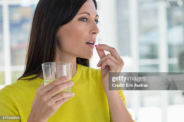 close-up of a woman taking medicine - taking pills stock pictures, royalty-free photos & images