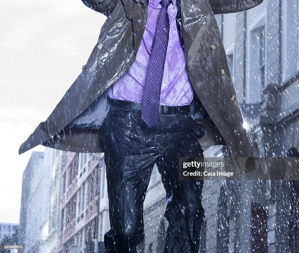 Businessman running in rain