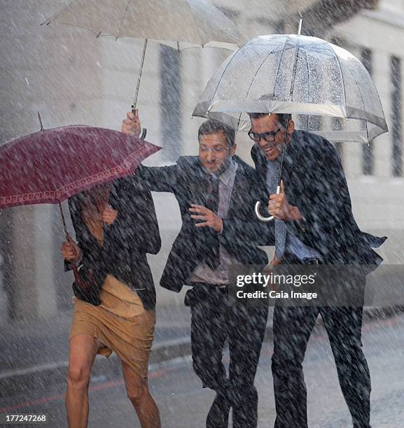 glücklich geschäftsleute mit sonnenschirmen laufen in regnerischen street - speed motion lines to the middle stock-fotos und bilder