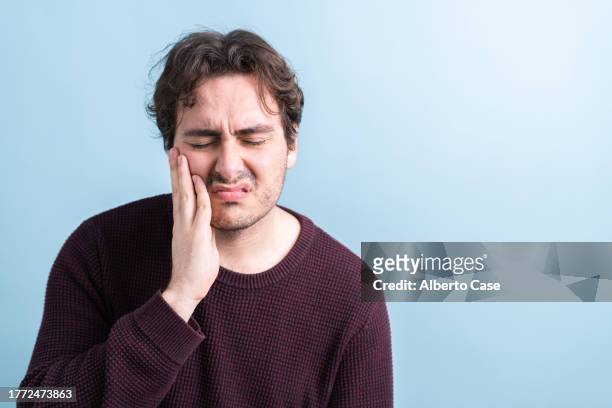 a man with a toothache - grief stock pictures, royalty-free photos & images