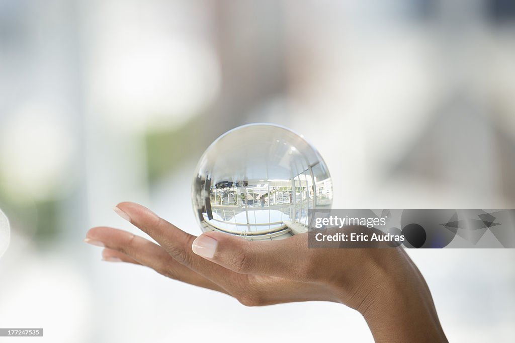 Close-up of a person's hand holding a crystal ball