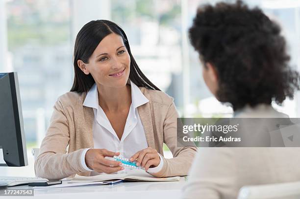 female doctor showing medicine to a patient - contraceptive stock-fotos und bilder