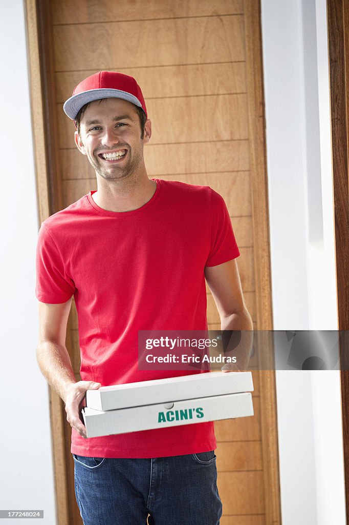 Portrait of a smiling deliveryman delivering pizza