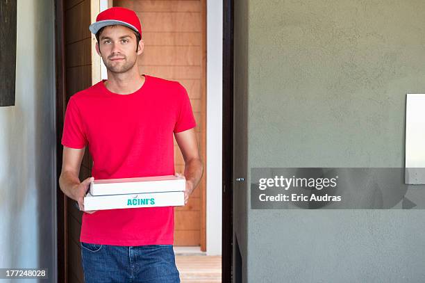 portrait of a deliveryman delivering pizza - tシャツ　キャッ��プ ストックフォトと画像