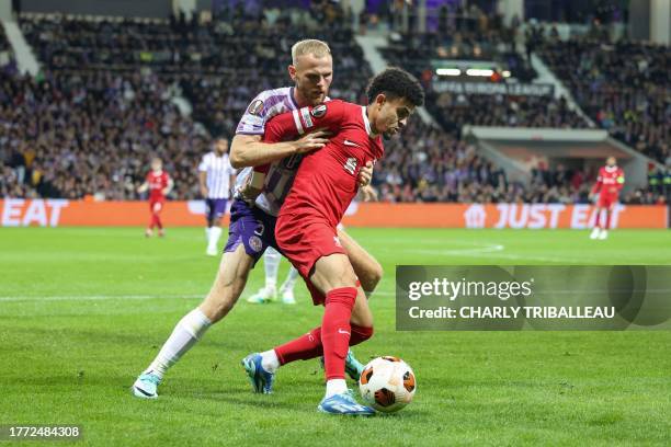 Liverpool's Colombian midfielder Luis Diaz and Toulouse's Danish defender Mikkel Desler Puggaard fight for the ball during the UEFA Europa League...