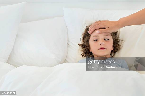 person's hand examining fever of a boy - child temperature stock pictures, royalty-free photos & images