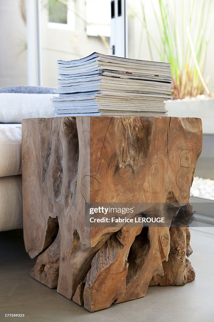 Stack of magazines on a table made from tree stump