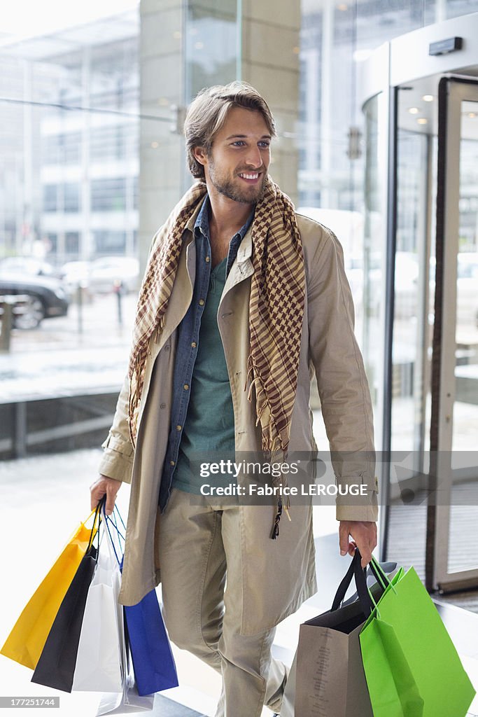 Man carrying shopping bags and smiling