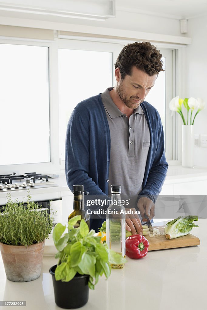 Man chopping vegetables in a kitchen