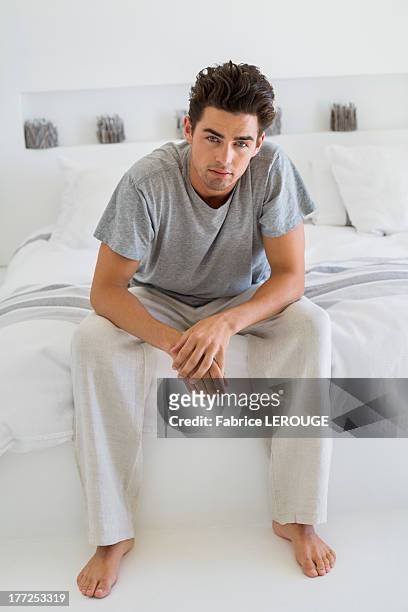 man sitting on the bed - pantaloni di tuta foto e immagini stock
