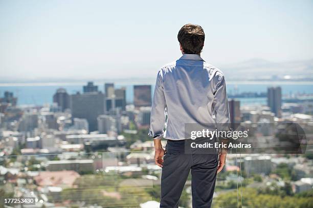 man standing on the terrace looking at a city - chemise homme photos et images de collection