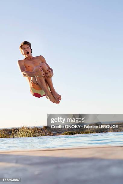 man jumping into a swimming pool - man floating in pool stock pictures, royalty-free photos & images