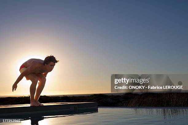 man about to jump into a swimming pool - jump in pool stock pictures, royalty-free photos & images