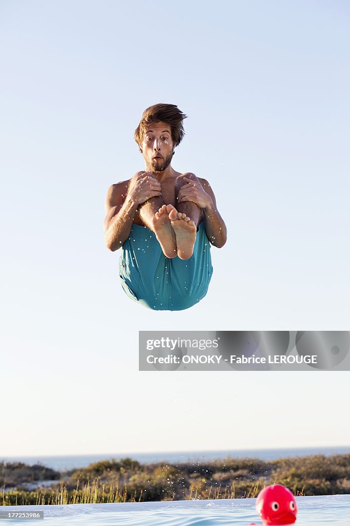 Man jumping into a swimming pool
