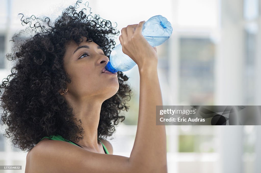 Close-up of a woman drinking water from a bottle