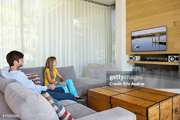 man and his daughter watching television - stereoanlage stock-fotos und bilder