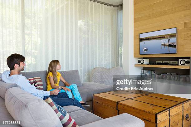 man and his daughter watching television - family rom stock pictures, royalty-free photos & images