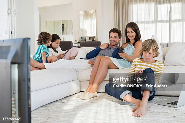 family using electronics gadget - tv phone tablet stock pictures, royalty-free photos & images