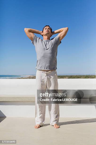man standing with hands behind head - jogging pants stock pictures, royalty-free photos & images