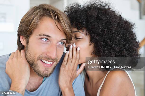 woman whispering to a man - people whispering imagens e fotografias de stock