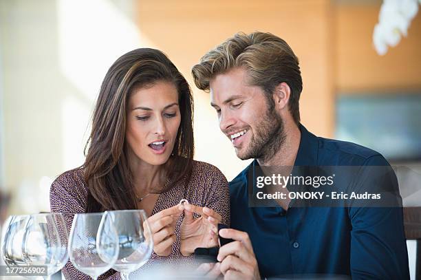 man giving engagement ring to his girlfriend in a restaurant - hand over mouth stock pictures, royalty-free photos & images