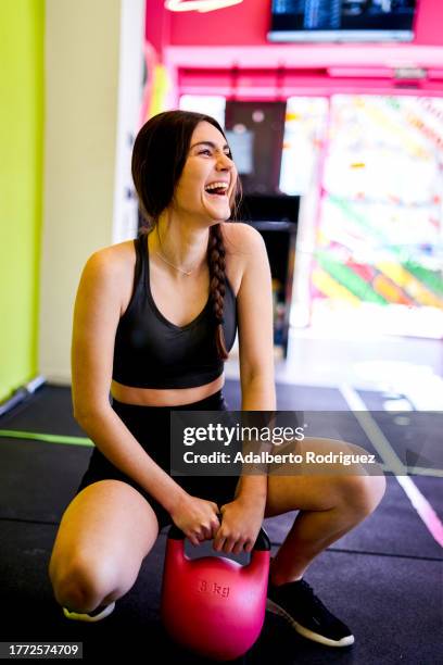 photo of a woman exercising with a red fitness ball in a gym - core strength stock pictures, royalty-free photos & images