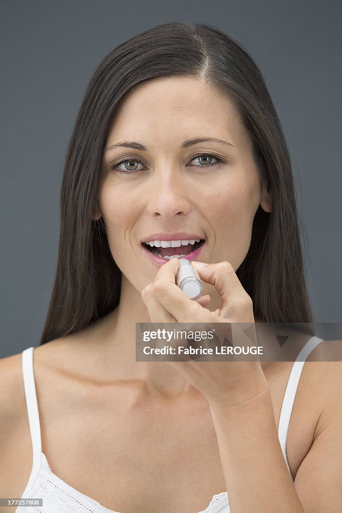 Woman applying lipstick