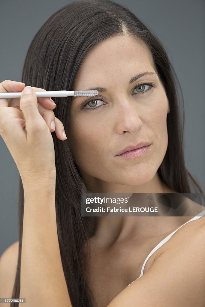 Portrait of a woman applying eyeliner