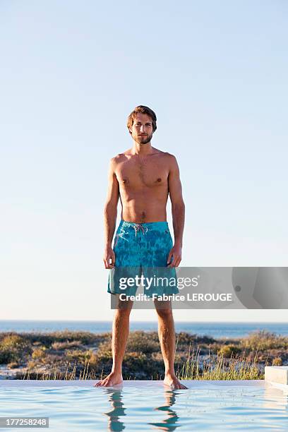 man standing at the poolside - zwembroek stockfoto's en -beelden