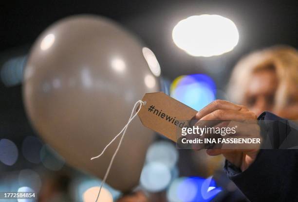 Woman holds a balloon with a note saying 'Never Again' during a rally organised by German parties in Dortmund, western Germany on November 9 to...