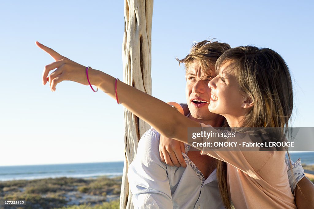 Woman sitting with her boyfriend and pointing away