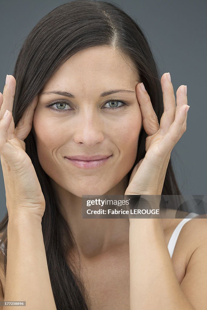 Portrait of a woman checking wrinkles on her face