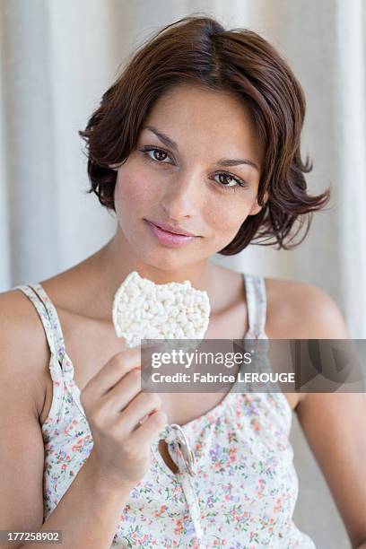 portrait of a woman eating rice cake - rijstwafel stockfoto's en -beelden