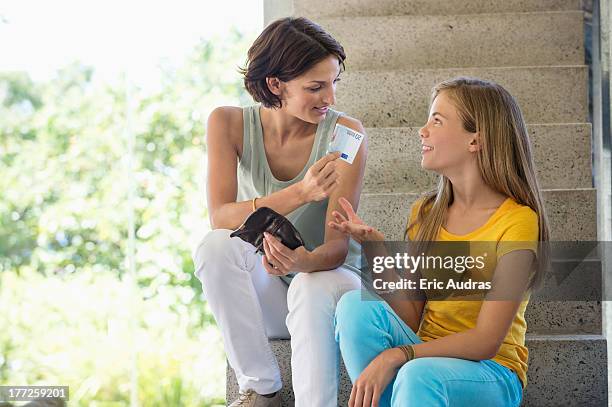 woman giving pocket money to her daughter - taschengeld kind stock-fotos und bilder