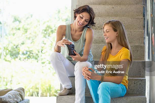 woman giving pocket money to her daughter - pocket money stock pictures, royalty-free photos & images