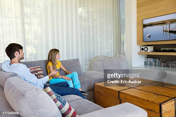 father watching television with his daughter - family rom stock pictures, royalty-free photos & images