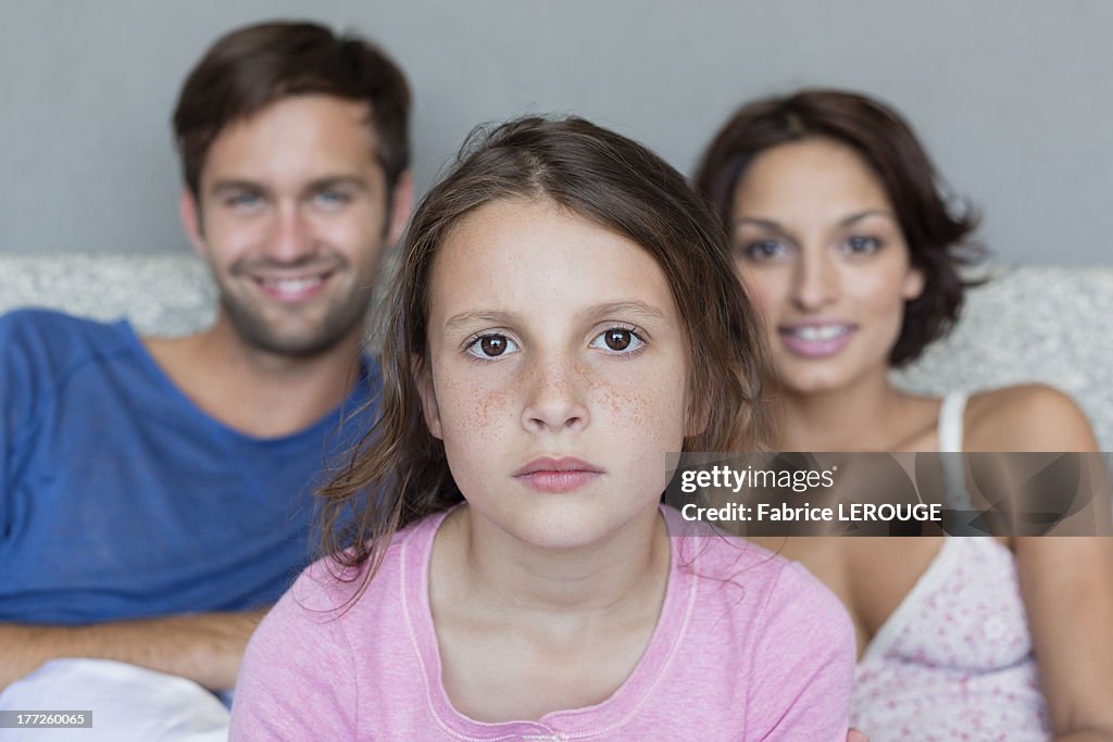 Portrait of a girl with her parents in the background